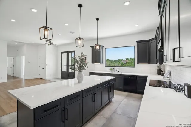 a kitchen with stainless steel appliances kitchen island granite countertop a sink and a refrigerator