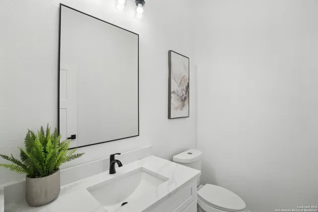 a bathroom with a sink a toilet and a mirror