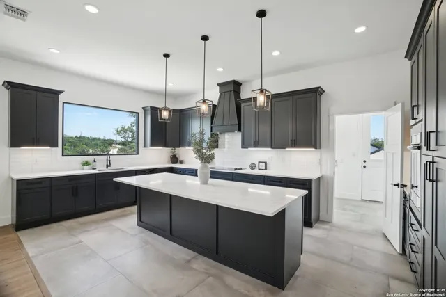 a kitchen with stainless steel appliances kitchen island a sink stove and refrigerator