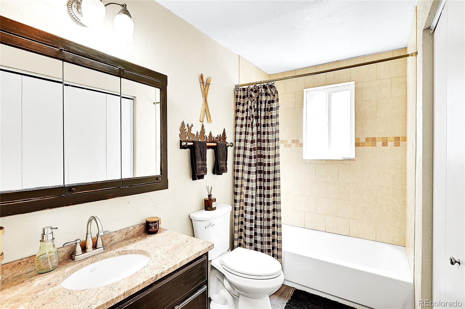30997 Witteman Road Conifer, CO 80433 - Photo 22 of 39 a bathroom with a granite countertop sink toilet and shower