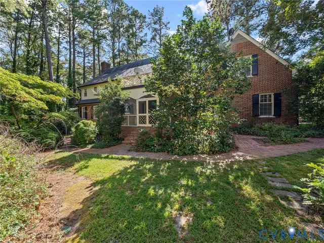 a backyard of a house with plants and large trees