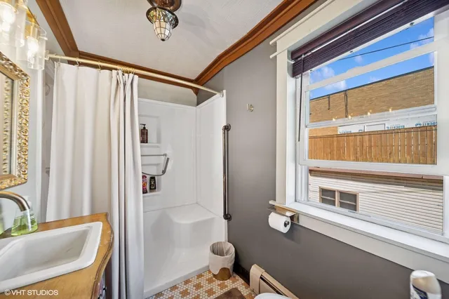 a bathroom with a granite countertop sink a mirror and a shower