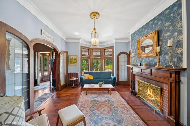 a living room with furniture a fireplace and large windows