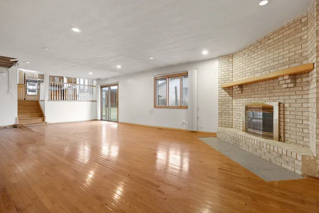 a view of empty room with wooden floor and fireplace