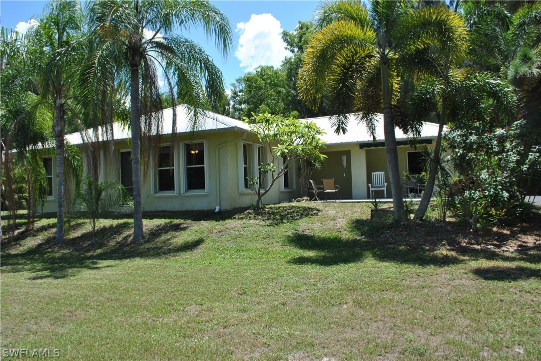 5824 Mackerel Road Bokeelia, FL 33922 - Photo 1 of 25 front view of house with a yard