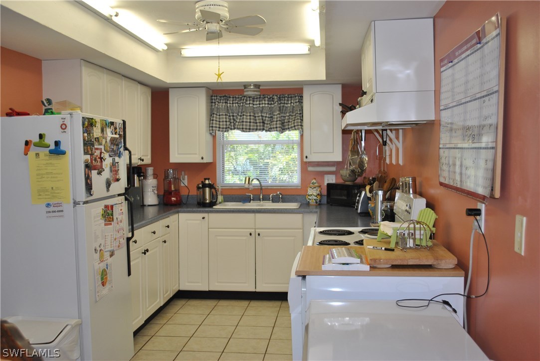 5824 Mackerel Road Bokeelia, FL 33922 - Photo 13 of 25 a kitchen with stainless steel appliances granite countertop a sink stove and refrigerator