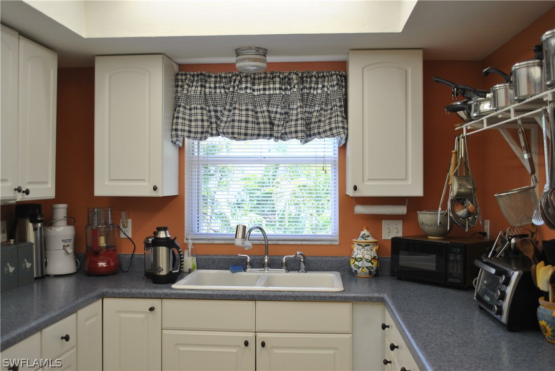 5824 Mackerel Road Bokeelia, FL 33922 - Photo 14 of 25 a kitchen with a sink cabinets and a window