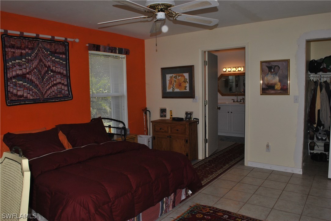 5824 Mackerel Road Bokeelia, FL 33922 - Photo 17 of 25 a bedroom with a bed and a chandelier