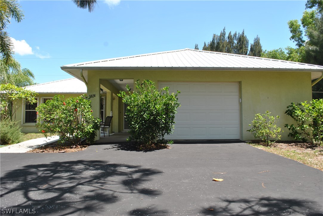 5824 Mackerel Road Bokeelia, FL 33922 - Photo 2 of 25 a view of a house with a yard and plants