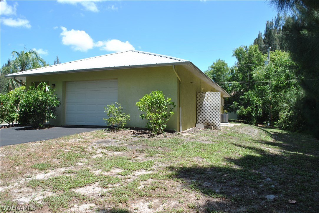 5824 Mackerel Road Bokeelia, FL 33922 - Photo 3 of 25 a backyard of a house with plants and garage