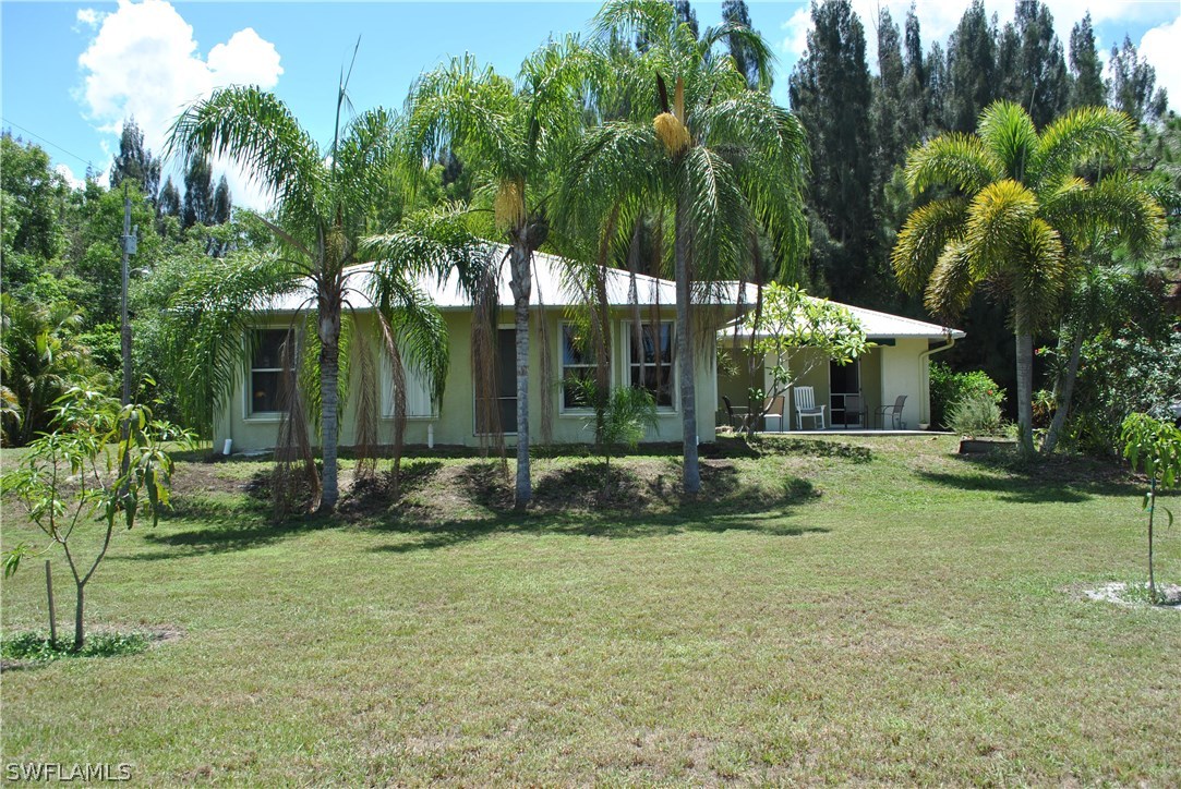 5824 Mackerel Road Bokeelia, FL 33922 - Photo 4 of 25 a view of house with backyard and a tree