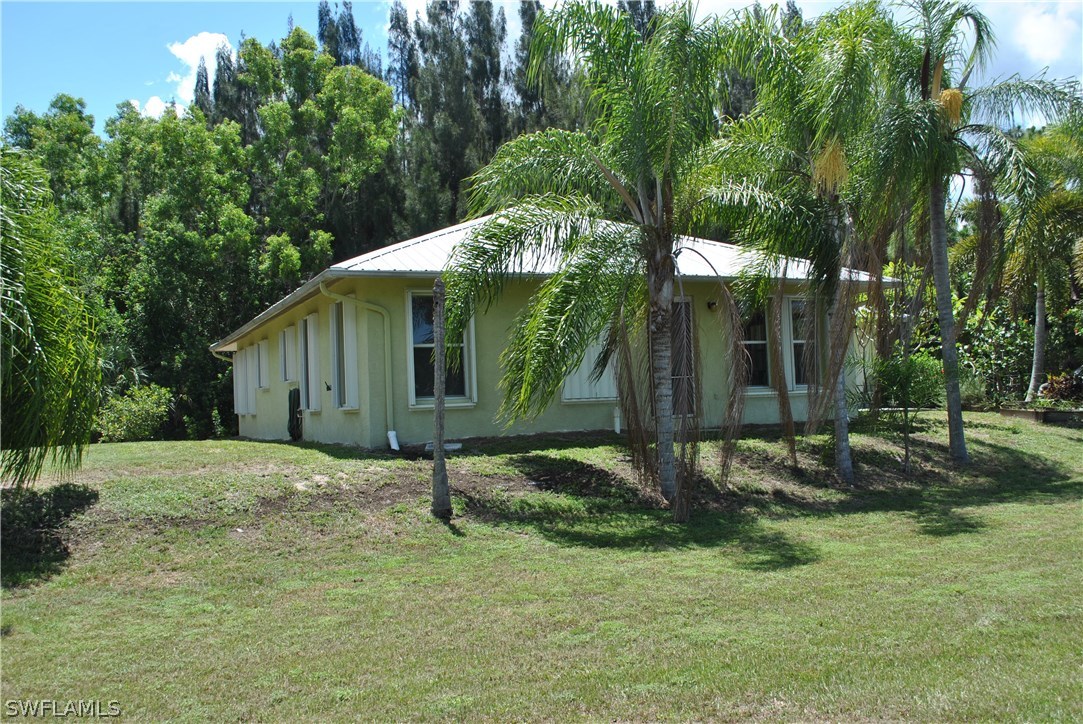 5824 Mackerel Road Bokeelia, FL 33922 - Photo 5 of 25 a backyard of a house with barbeque oven table and chairs