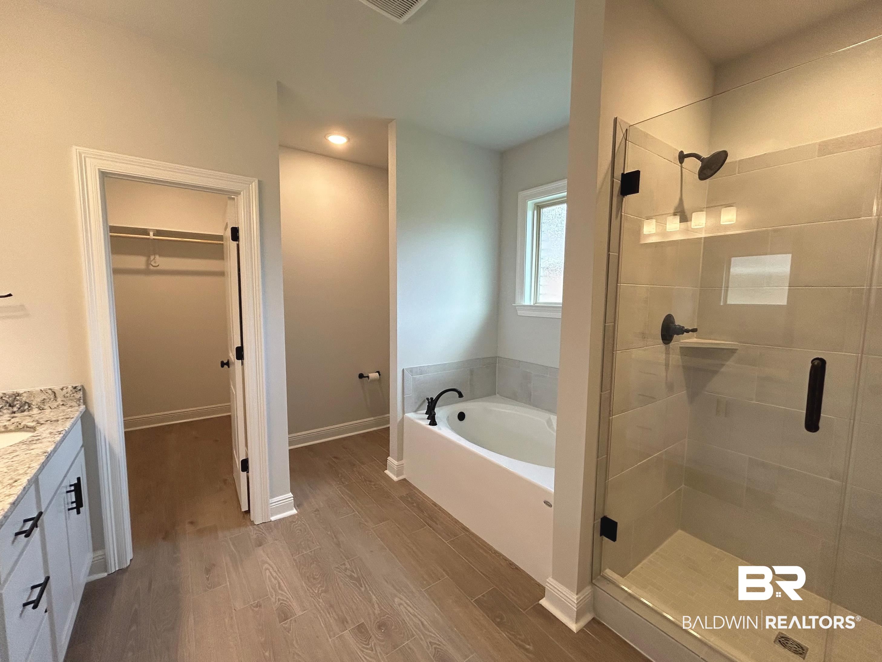 860 Sumter Loop Foley, AL 36535 - Photo 15 of 26 Bathroom with plus walk in shower, wood-type flooring, and vanity