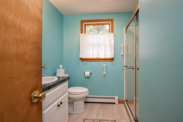 a bathroom with a granite countertop toilet sink and mirror