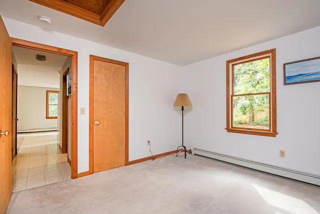 a view of an empty room with wooden floor and staircase