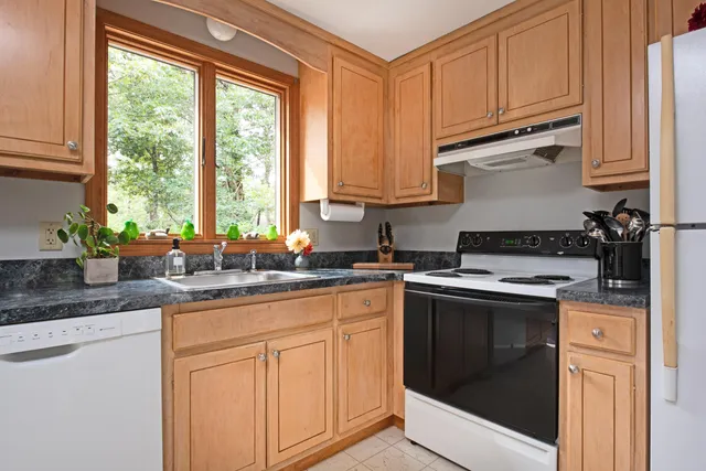 a view of a livingroom with furniture a ceiling fan and refrigerator