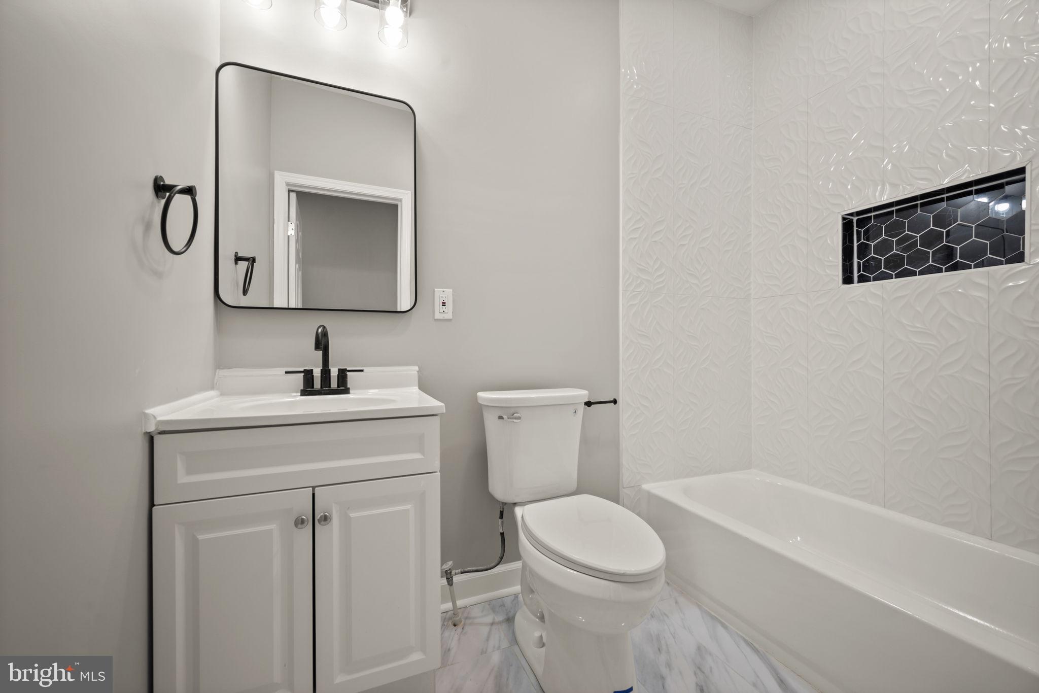 217 North Port Street Baltimore, MD 21224 - Photo 19 of 31 a bathroom with a toilet sink and mirror