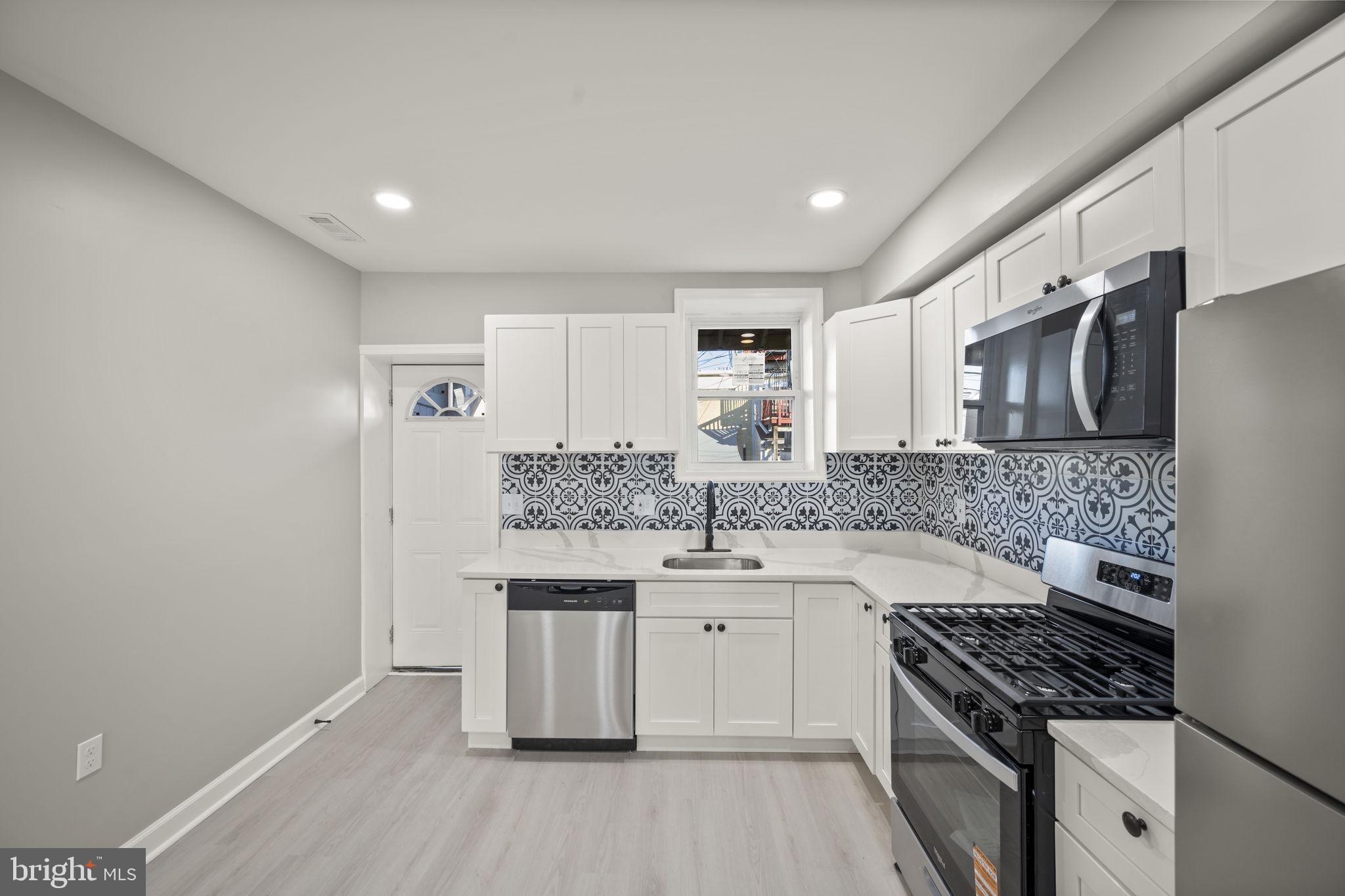 217 North Port Street Baltimore, MD 21224 - Photo 9 of 31 a kitchen with stainless steel appliances granite countertop a stove and a sink