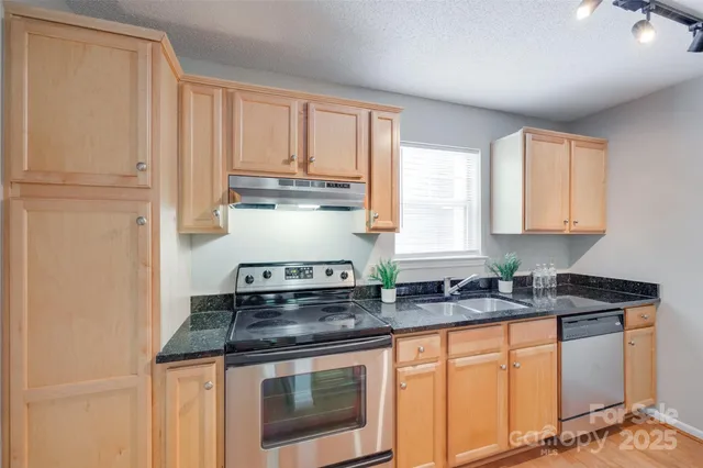 a kitchen with stainless steel appliances granite countertop white cabinets and a granite counter tops