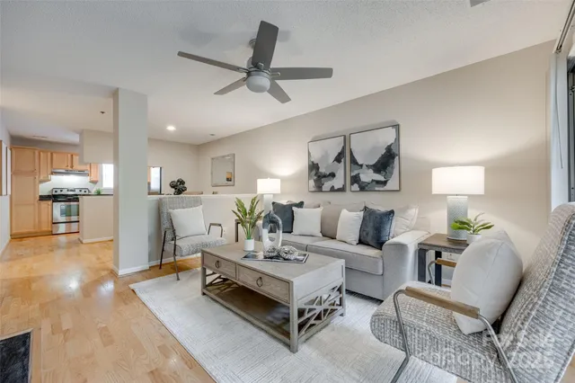 a living room with furniture and a view of kitchen