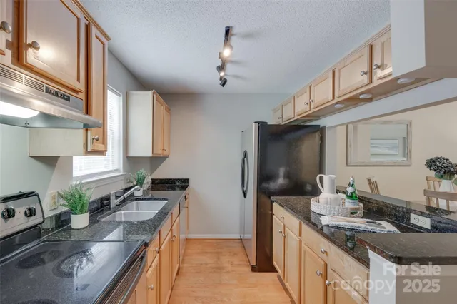 a kitchen with stainless steel appliances granite countertop a sink stove and cabinets