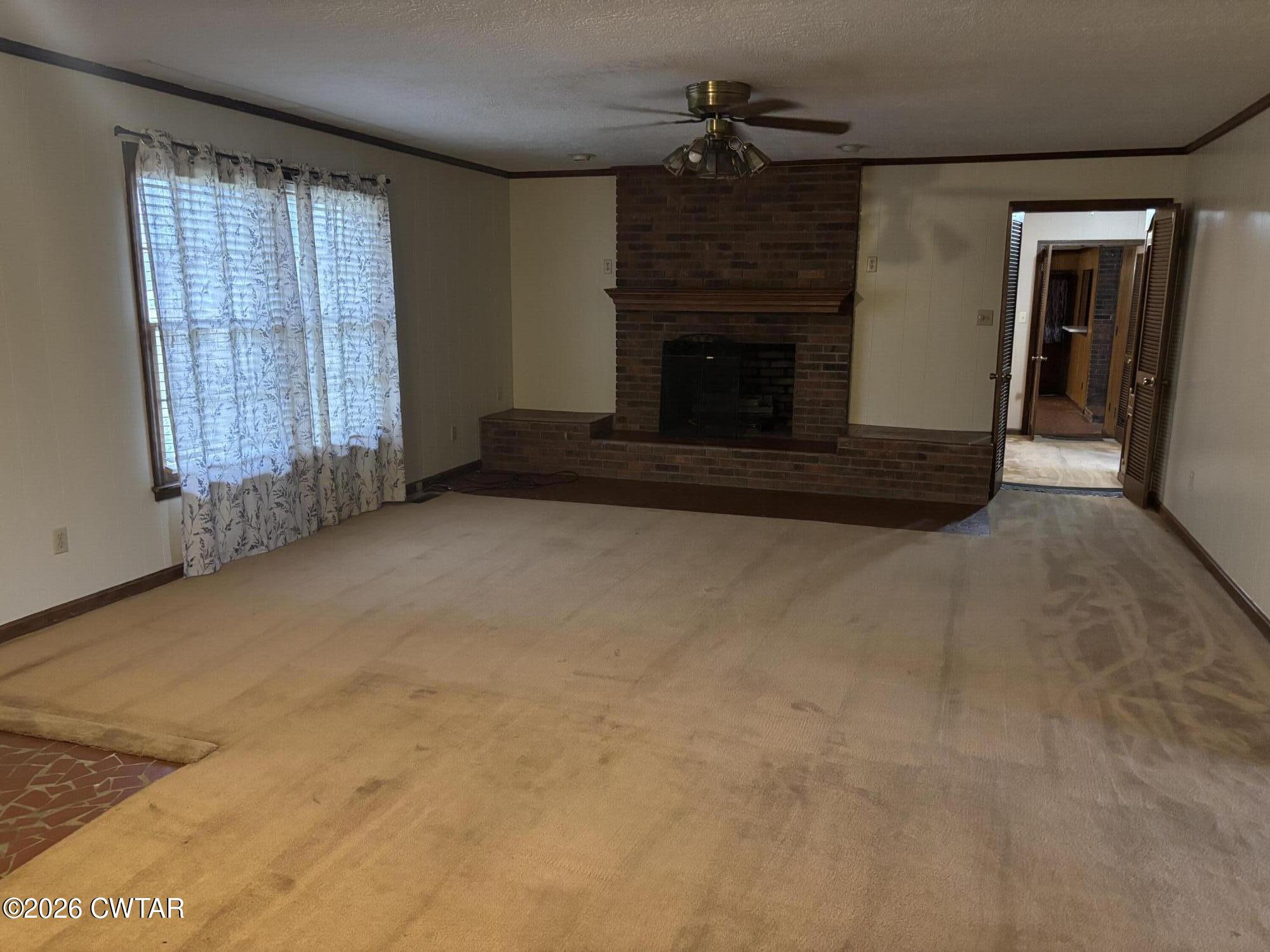 119 Casey Road Pinson, TN 38366 - Photo 10 of 10 an empty room with windows fireplace and cabinet