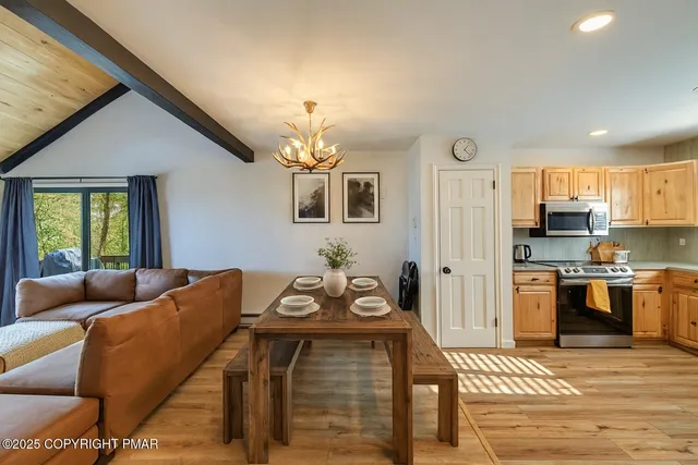 a living room with stainless steel appliances kitchen island granite countertop furniture and a fireplace