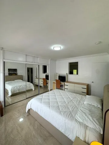 a bedroom with a large bed and a couch