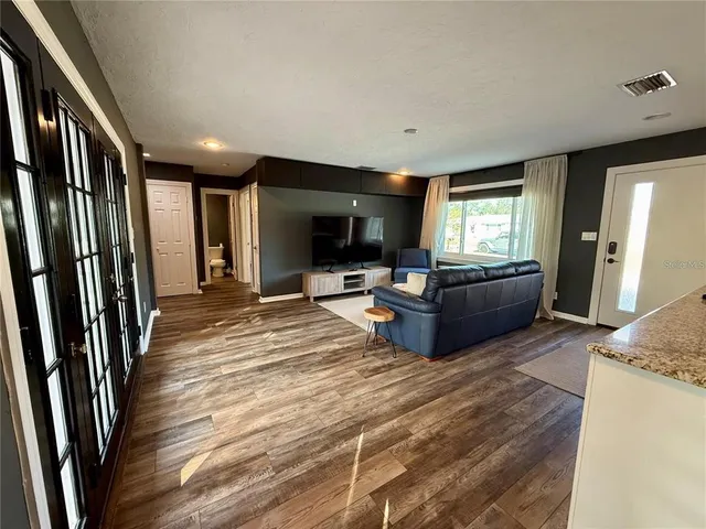a living room with furniture flat screen tv and a refrigerator