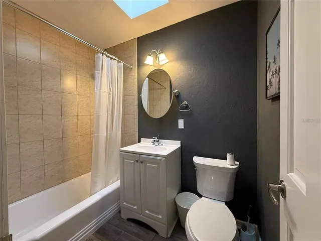 a bathroom with a toilet sink vanity tub and shower