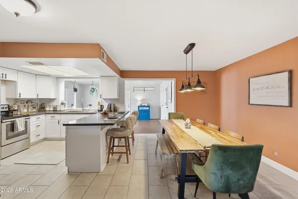 a dining room with stainless steel appliances kitchen island a table and chairs
