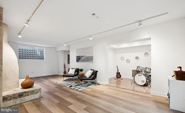 a living room with furniture a rug and white walls