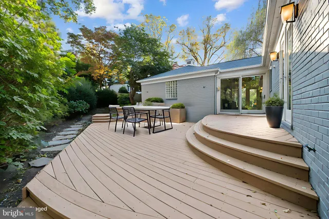 a view of a patio with table and chairs with wooden floor and fence