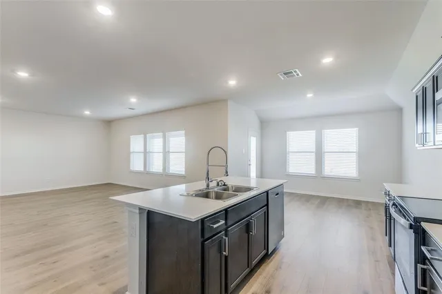 a kitchen with a sink cabinets and wooden floor