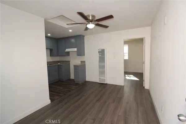 a view of empty room with wooden floor and ceiling fan