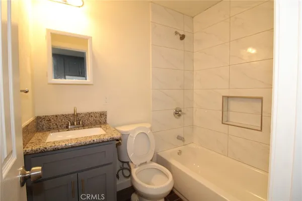 a bathroom with a granite countertop toilet a sink and bathtub