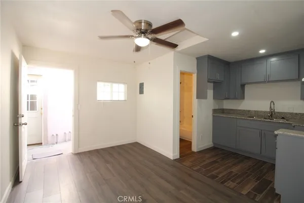 a view of a kitchen with a sink dishwasher and wooden floor