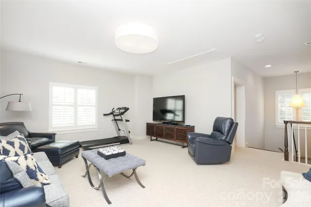 a living room with furniture a flat screen tv and a window