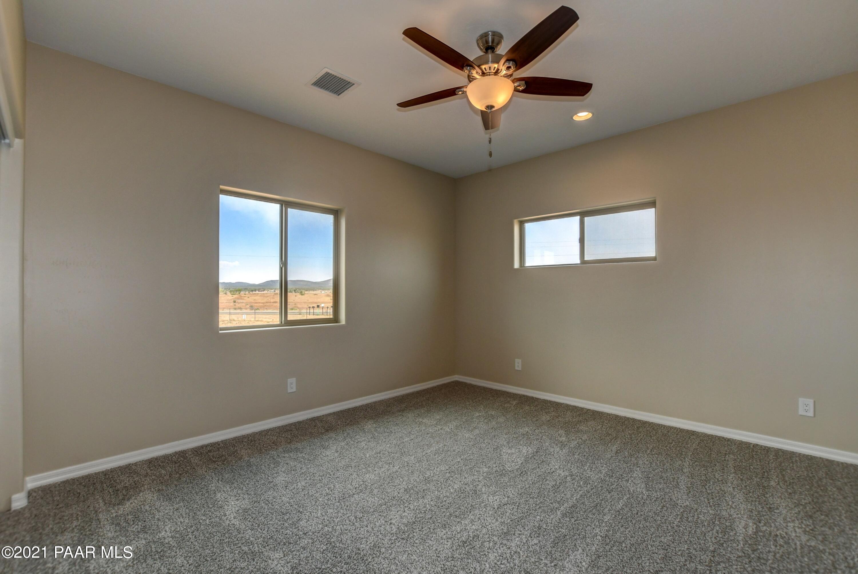 1495 Saddle Road Paulden, AZ 86334 - Photo 12 of 33 an empty room with a window and a fan
