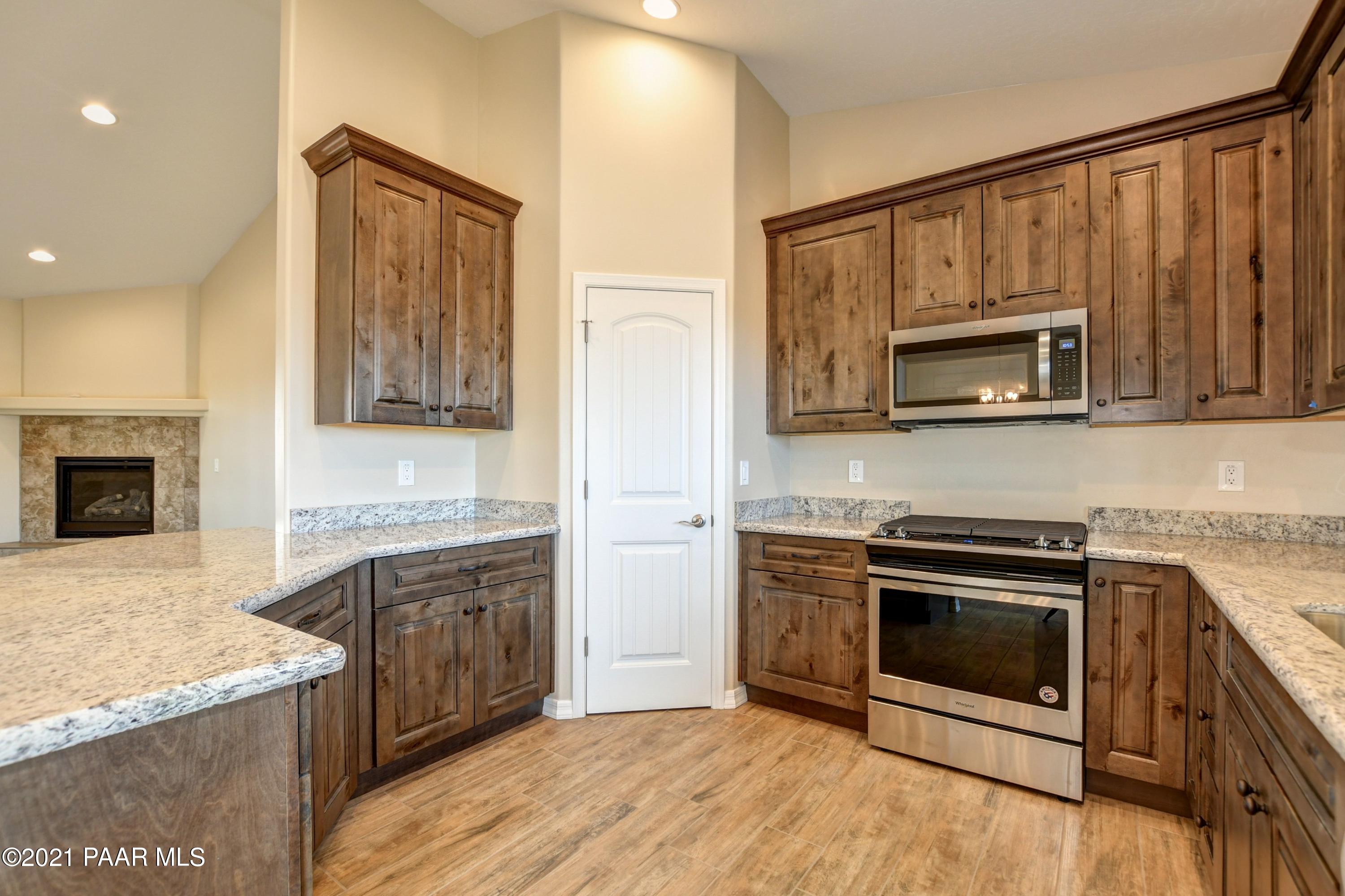 1495 Saddle Road Paulden, AZ 86334 - Photo 24 of 33 a kitchen with granite countertop a stove top oven microwave and refrigerator