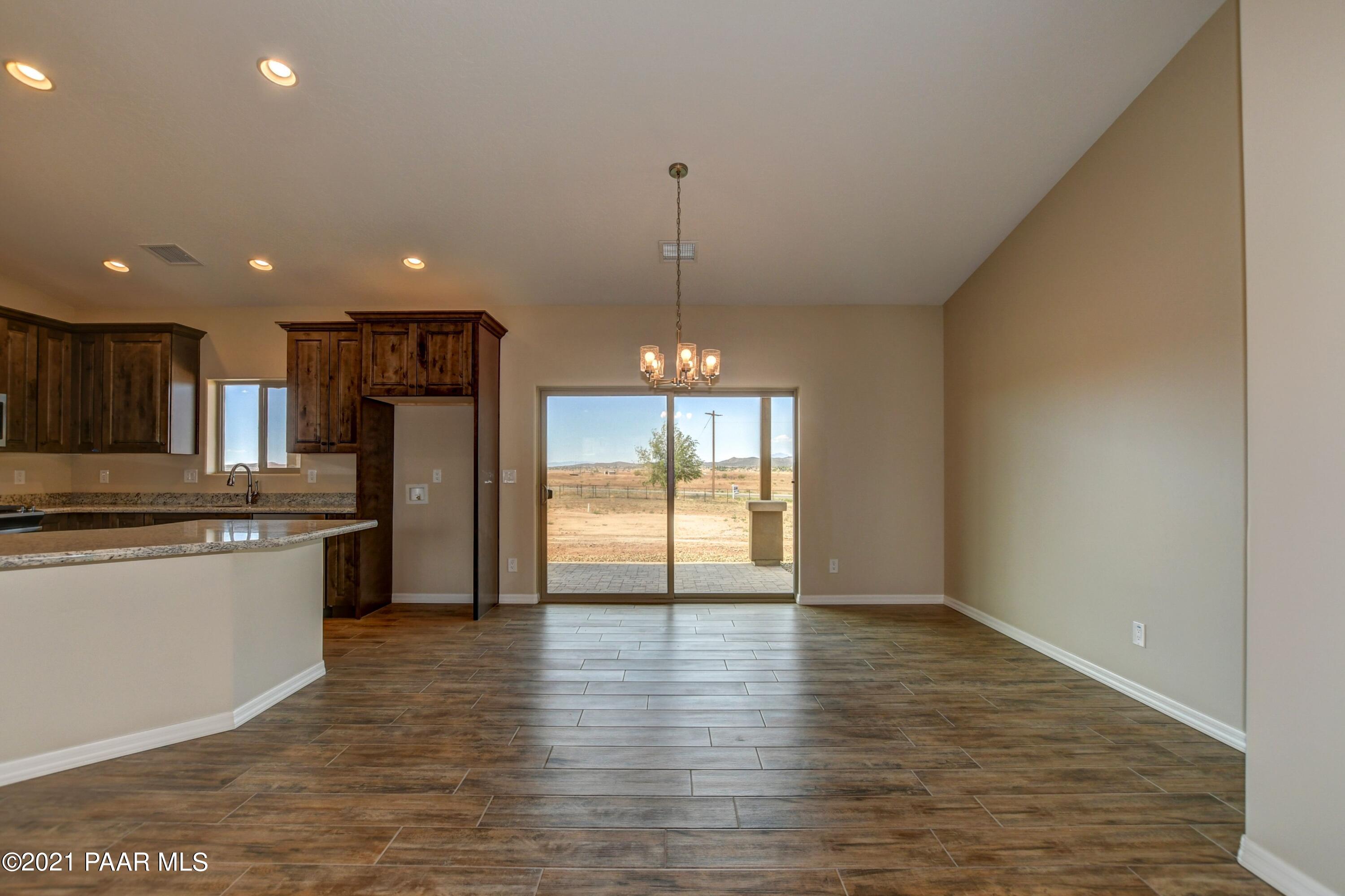 1495 Saddle Road Paulden, AZ 86334 - Photo 5 of 33 a kitchen with stainless steel appliances granite countertop a refrigerator a sink dishwasher a stove and white cabinets with wooden floor