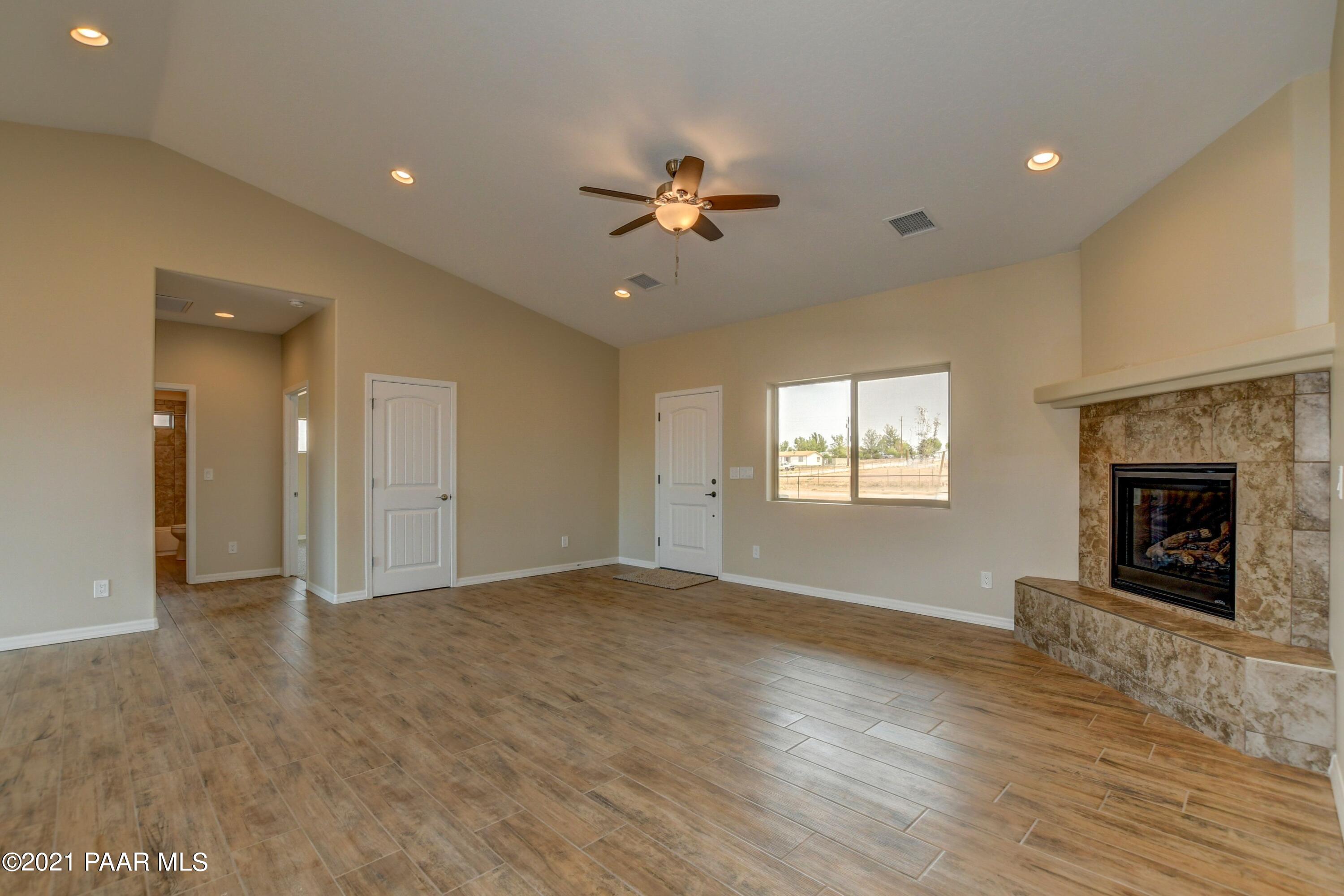 1495 Saddle Road Paulden, AZ 86334 - Photo 8 of 33 an empty room with windows and a fireplace