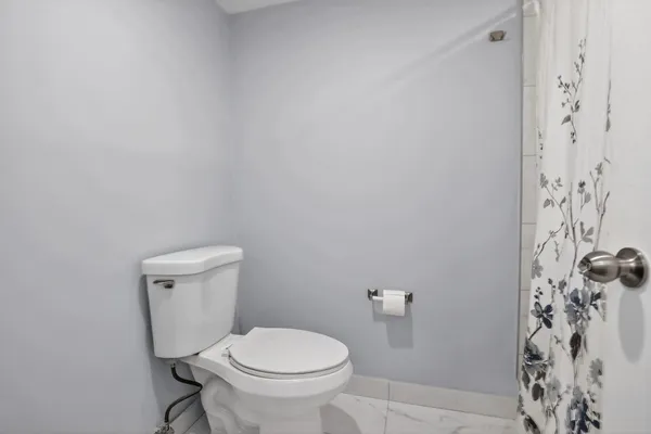 a white toilet sitting next to a shower curtain