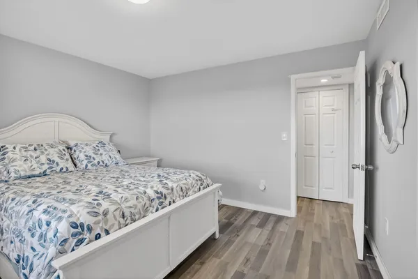 a bedroom with a bed and wooden floor