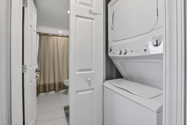 a view of washer and dryer with bathroom in the background