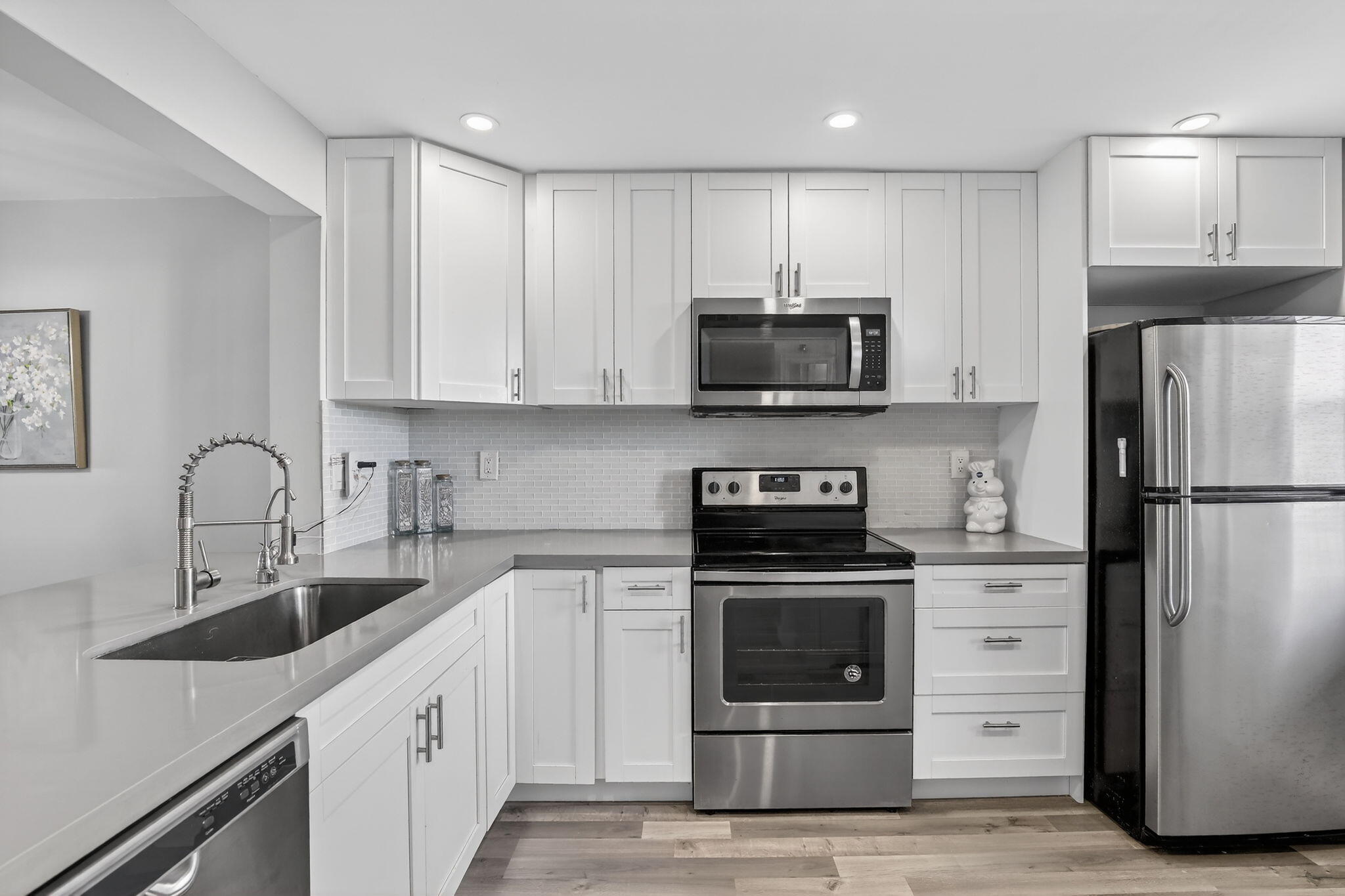 3910 Inverrary Boulevard, Unit 802B Lauderhill, FL 33319 - Photo 6 of 36 a kitchen with refrigerator a microwave a sink and cabinets