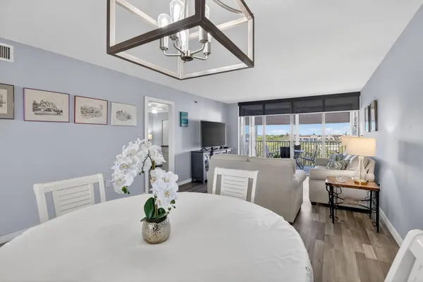 a dining room with furniture large window and wooden floor