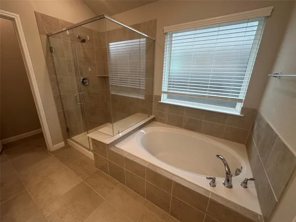 a bathroom with a tub a sink and a shower