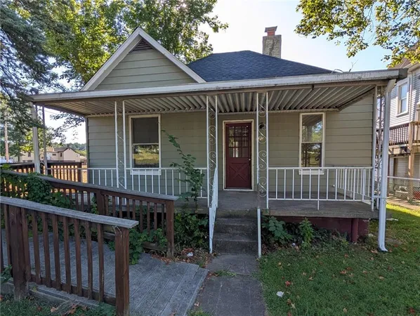 a view of a house with wooden deck and furniture