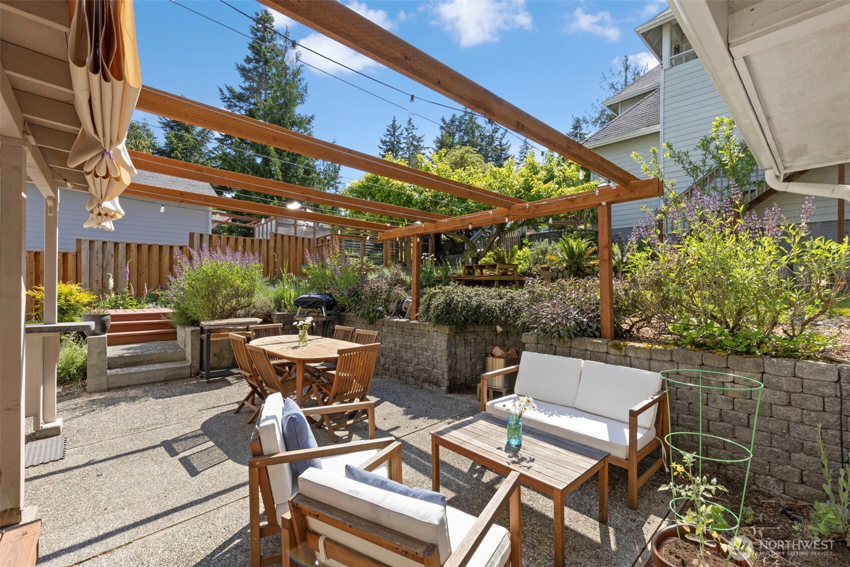 4375 Erin Street Port Townsend, WA 98368 - Photo 23 of 40 a view of a patio with table and chairs potted plants and large tree